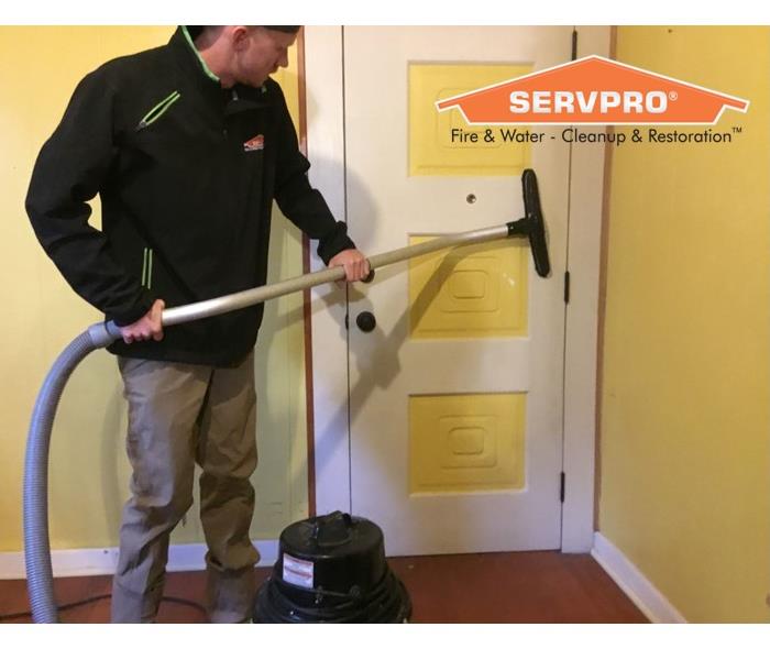 Man using a vacuum cleaning on a door