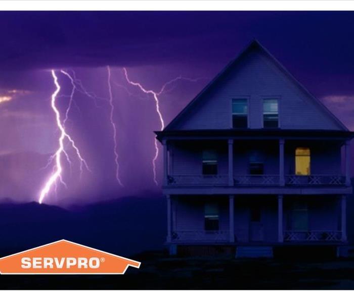 Lightning striking behind a house with SERVPRO logo